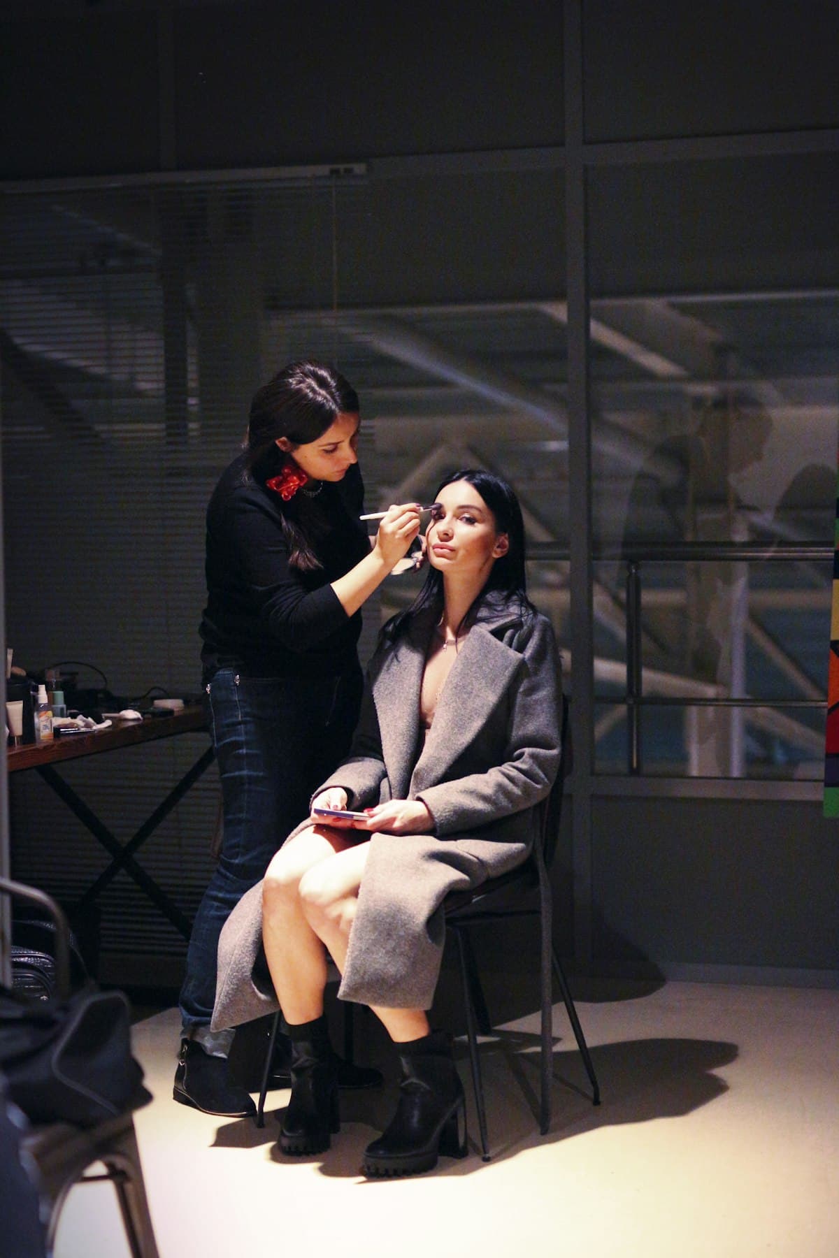 An artist doing a model's makeup in a studio